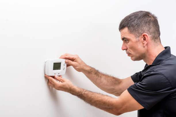 technician installing faceplate on a digital thermostat